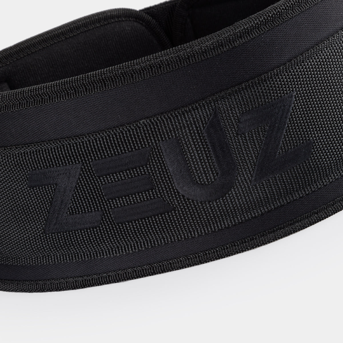 Close-up van het geborduurde ZEUZ logo op de gewichthefriem zwart